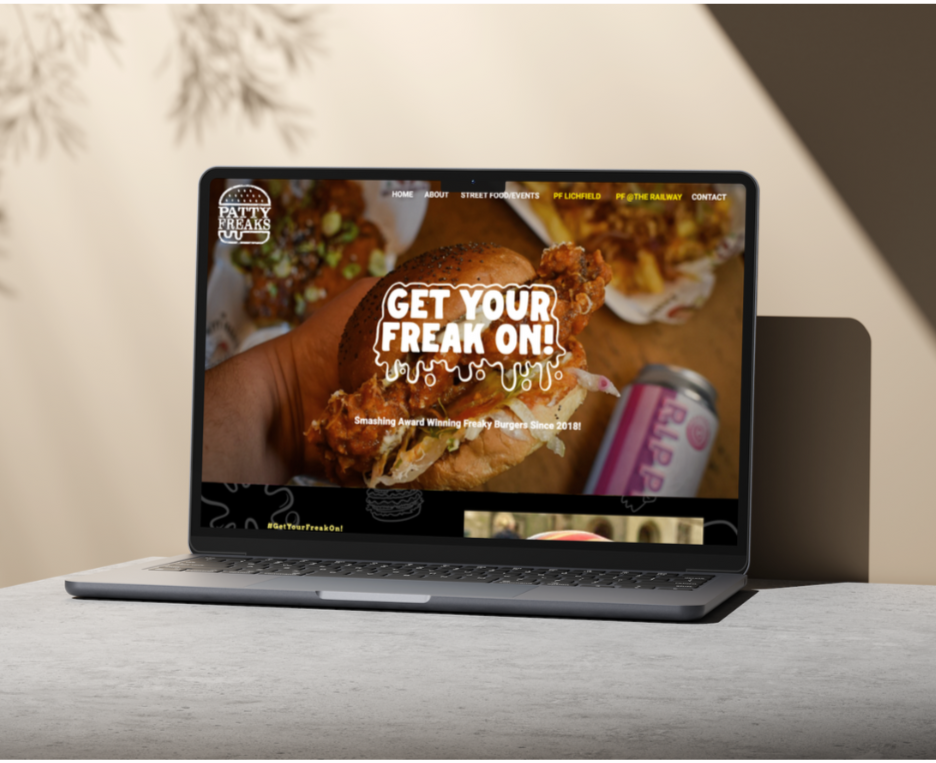 Laptop against a wall on a grey surface, displaying The Patty Freaks burger restaurant home page