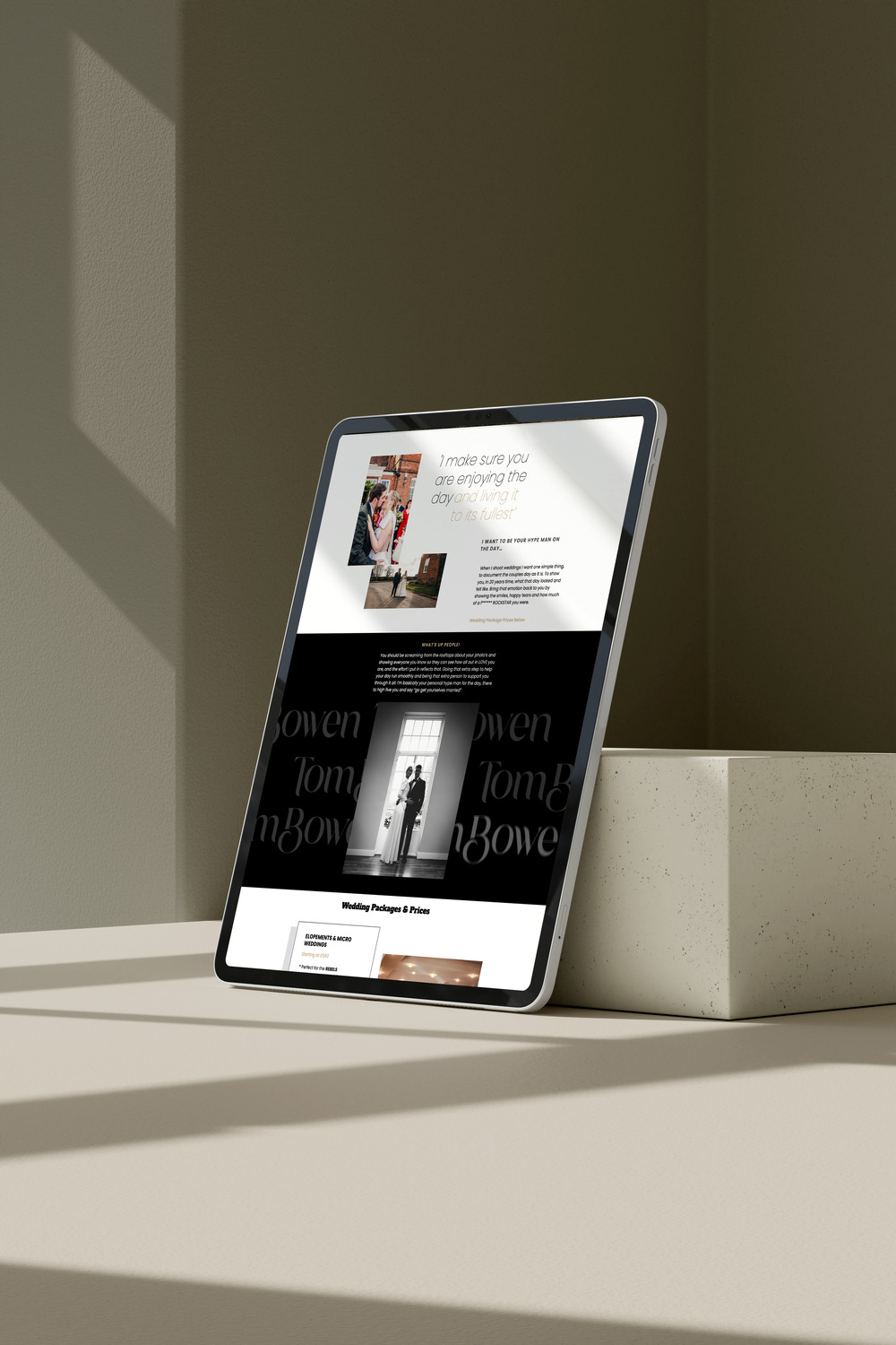 A tablet displaying a wedding photography website stands on a beige surface against a muted background with soft shadows. The website features a mix of colour and black-and-white photos of weddings, showcasing joyful moments and elegant compositions. The visible text highlights the photographer's commitment to ensuring clients enjoy their special day to the fullest.