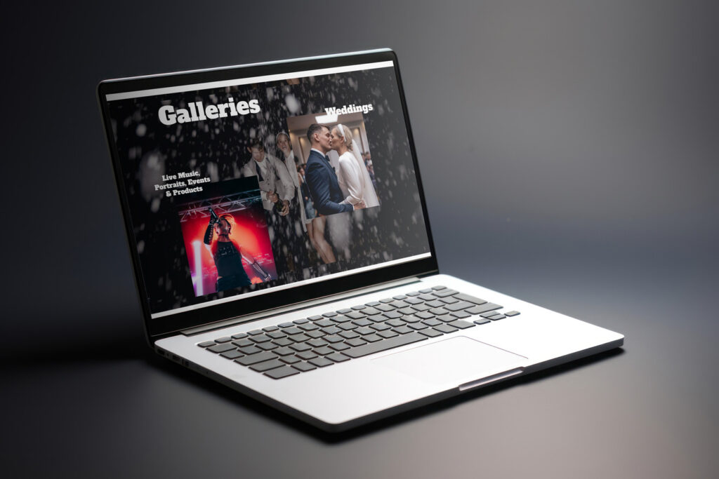 A laptop displaying a photographer's website with sections for "Galleries" and "Weddings." The screen shows images of a live music performance and a wedding couple kissing, with a sleek, dark background.