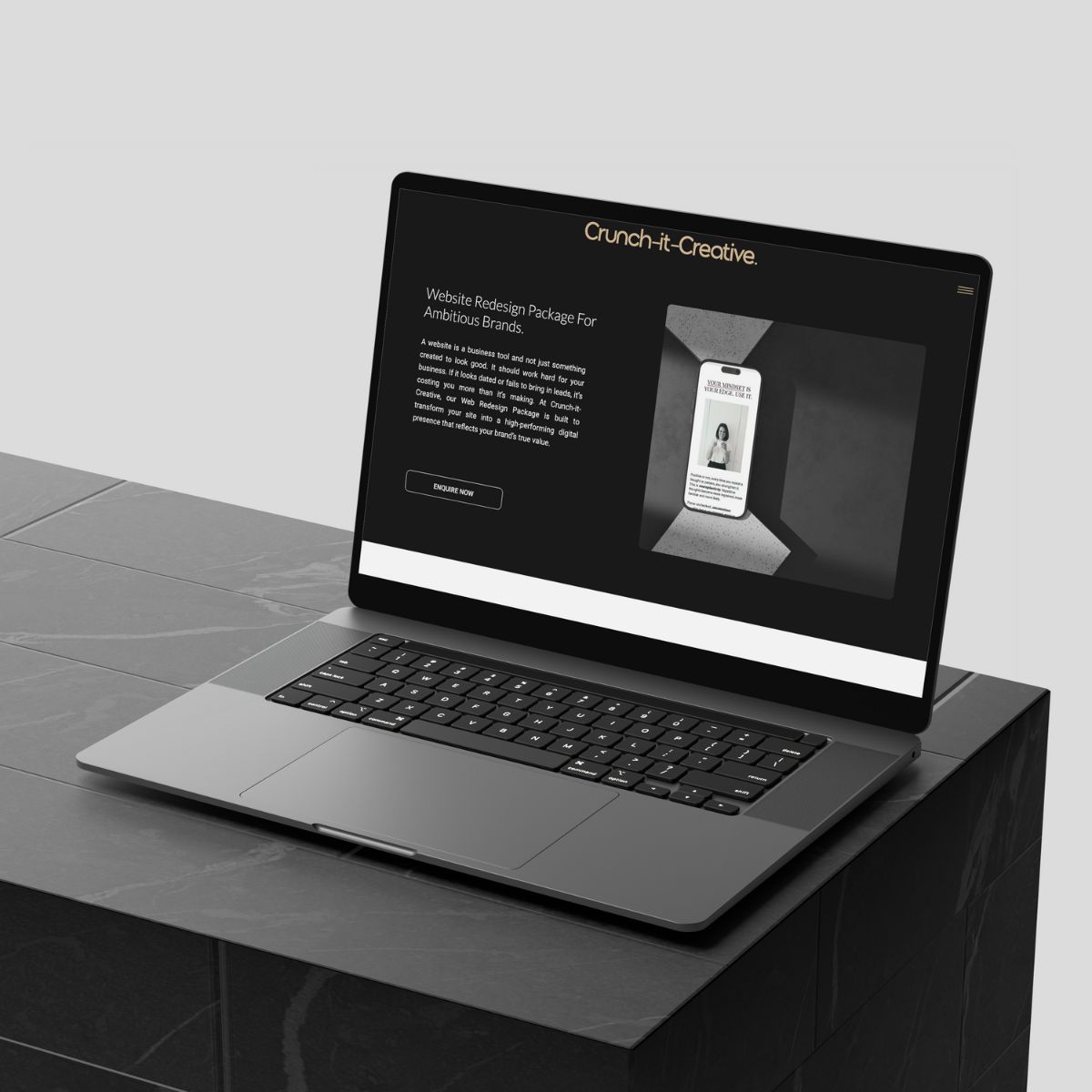 Laptop tilted right showing a website redesign specialist package for ambitious brands with a phone mockup